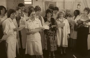 The RVH PCU team singing - Dr. Balfour Mount, 4th from the left, Susan playing guitar on the far right.