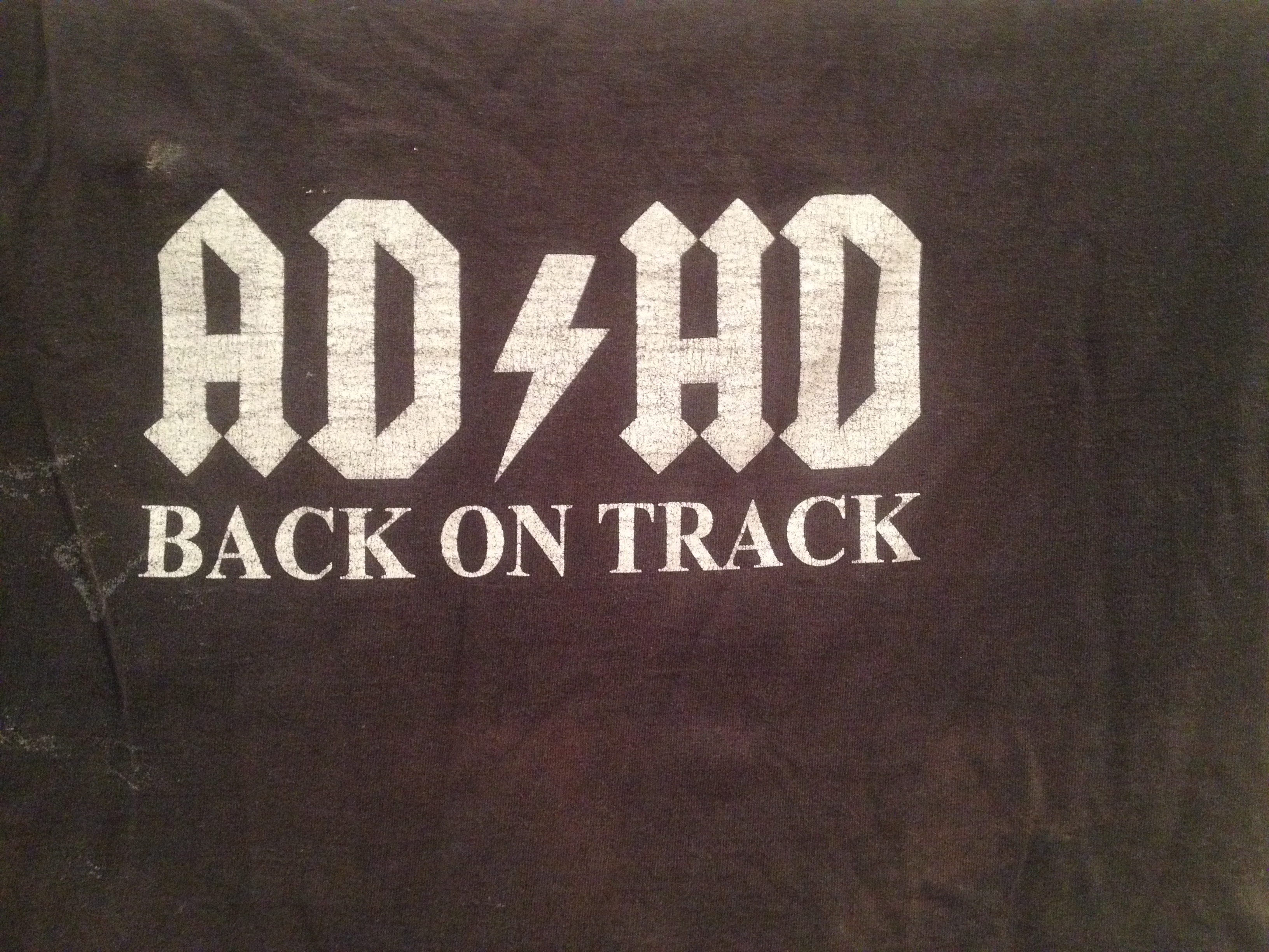 t-shirt with a print based on the logo of AC/DC, which reads AD/HD